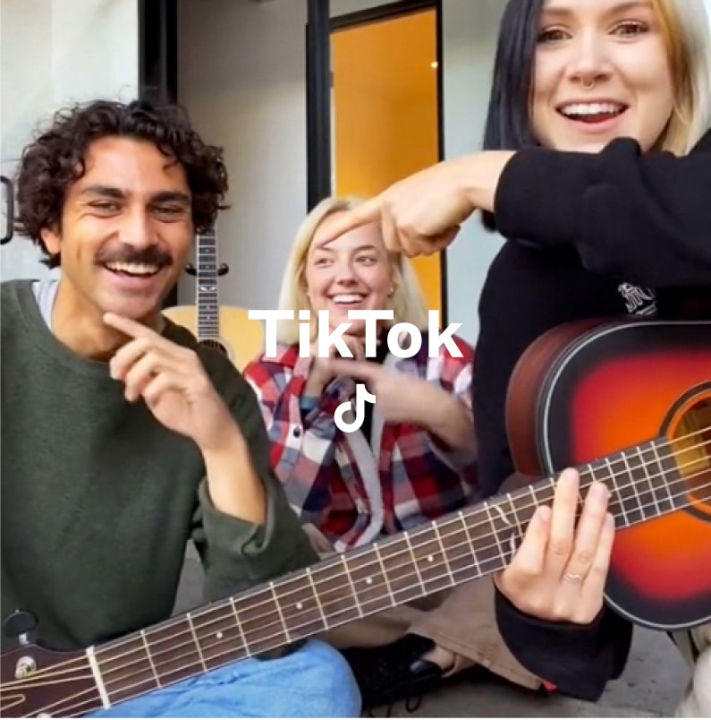 Three people in front of a camera with tiktok logo overlaid