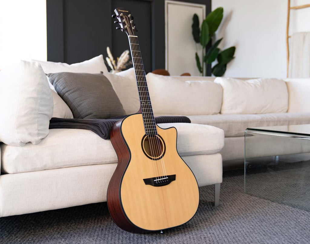 Morgan Mahogany spruce guitar against a white sofa